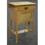 An early 20th Century Arts and Crafts stripped oak pot cupboard or bedside cabinet,