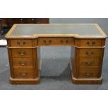 An early 20th Century oak twin pedestal desk fitted with nine drawers around the kneehole,