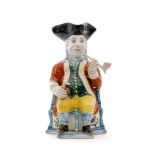 A 19th Century Squire Toby jug, seated on a corner chair wearing a brown frock coat,