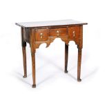 A George III oak and mahogany crossbanded lowboy fitted with three drawers above a shaped apron on