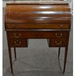 An Edwardian inlaid mahogany cylinder desk with pigeon hole and drawer interior above three frieze