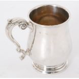 A hallmarked silver baluster pint tankard of plain form with acanthus capped scroll handle,