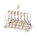 A George III hallmarked silver six division toast rack of shield shape on rectangular gadroon base