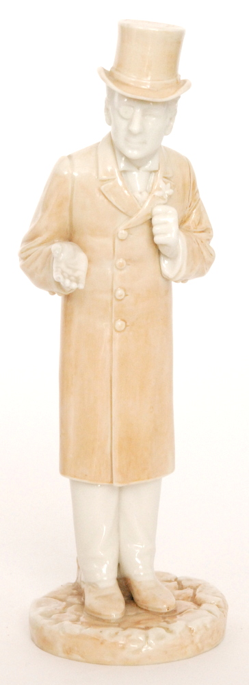 A late 19th Century figure of a gentleman dressed in a long over coat and top hat,