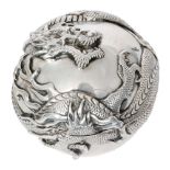 An early 20th Century Chinese silver circular box and cover decorated with a relief moulded dragon,