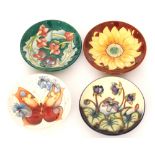 Four assorted Moorcroft Pottery pin dish coasters comprising one in the Butterfly and one in the