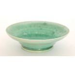 A Ruskin Pottery eggshell bowl of flared form decorated in an all over tonal green,