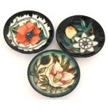 Three assorted Moorcroft Pottery pin dish coasters comprising one in the Passionfruit pattern