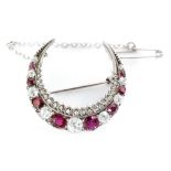 A silver Edwardian garnet and diamond crescent brooch, alternating graduated stones,