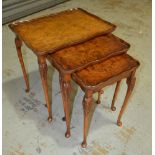 A nest of three Queen Anne style walnut occasional tables on slender cabriole legs,