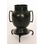 An early 20th Century Japanese bronze two handled vase of plain form on serpentine shaped base and