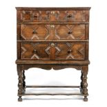 An oak chest of three graduated geometric panelled drawers in the 18th Century style,