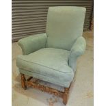 A 1930s oak framed easy chair on block legs and stretcher upholstered in green damask