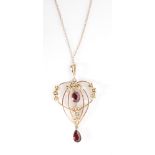 An Edwardian 9ct garnet and seed pearl open work pendant, 5cm, suspended from fine chase chain.