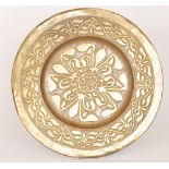 An Arts and Crafts brass charger with stylised flower head to the centre,