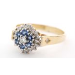 An 18ct hallmarked sapphire and diamond cluster ring central brilliant cut diamond within a six