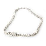 An 18ct white gold diamond tennis bracelet formed of seventy five round brilliant cut diamonds,