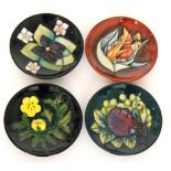Four assorted Moorcroft Pottery pin dish coasters all decorated in patterns designed by Sally