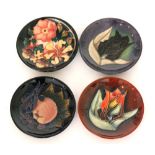 Four assorted Moorcroft Pottery pin dish coasters comprising three designed by Sally Tuffin in the