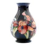 A large Moorcroft footed baluster vase decorated in the Frilled Orchid pattern with a band of