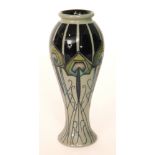 A Moorcroft Pottery vase of slender form with a flared foot decorated in the Peacock Parade pattern