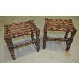 A pair of 1930s oak framed stools with leather strapwork seats, on turned block legs, width 40cm,