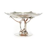 An Orivit pewter and glass pedestal tazza circa 1900 with a shallow dish form top with relief