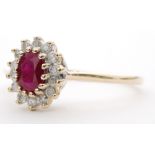 A 9ct ruby and diamond cluster ring, central oval ruby within a fourteen stone diamond surround,