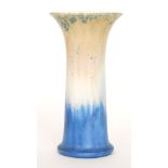 A Ruskin Pottery trumpet vase decorated in a mottled pale orange to blue with green crystalline