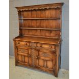 A 17th Century style oak dresser fitted with two frieze drawers over a cupboard base,