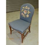 An early 20th Century easy chair on mahogany sabre legs upholstered in floral blue spray fabric.