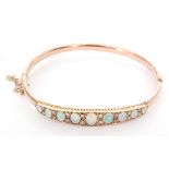 AMENDED DESCRIPTION - A 9ct rose gold synthetic opal and diamond hinged bangle,