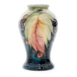 A small 1930s Moorcroft vase of inverted baluster form decorated in the Leaf and Berry pattern with