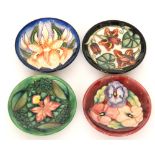 Four assorted Moorcroft Pottery pin dish coasters comprising one in the Pansy pattern designed