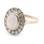 A 14ct opal and diamond dress ring, oval cabochon opal within in a sixteen diamond surround,