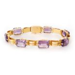 An 18ct mid 20th Century amethyst bracelet, seven emerald cut,