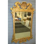 A Georgian style gilt framed wall mirror, the bevelled glass plate below a scallop scroll pediment,