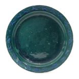 A Ruskin Pottery souffle glaze plate decorated in a blue green glaze with a hand painted border