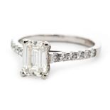 A platinum and diamond solitaire ring, emerald cut diamond weighing approximately 1ct,