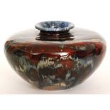 A Black Ryden vase of compressed form decorated in a streaked red, blue and sand glaze,