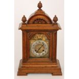 A late 19th to early 20th Century oak cased mantle clock with eight day striking movement on a gong,
