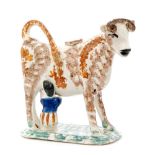 An early 19th Century Prattware cow creamer and cover with seated milk maid,