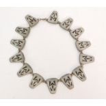 A 1950s Danish pewter necklace designed as fourteen panels each decorated with an Aztec Frog motif,