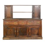 A 19th Century oak three drawer dresser base fitted with pierced brass handles on cupboard plinth