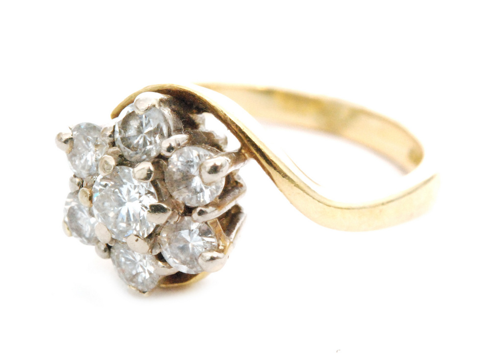 A modern 18ct diamond cluster ring, seven brilliant cut claw set stones to a twist and plain shank,