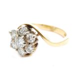 A modern 18ct diamond cluster ring, seven brilliant cut claw set stones to a twist and plain shank,