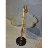 A Victorian mirrored display stand with central brass column on black glass base, diameter 36cm.