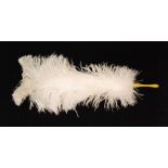 A 1930s single ostrich feather fan with yellow Bakelite handle, length ,