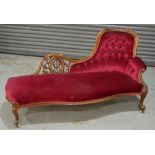 A Victorian carved mahogany framed chaise longue upholstered in crimson buttoned back plush,