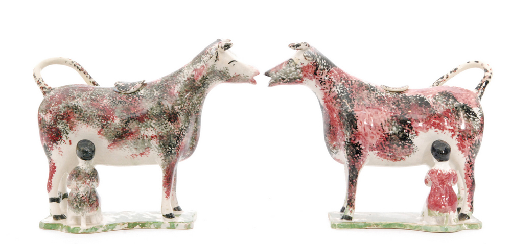 A mirrored pair of early 19th Century creamware cow creamers and covers each with milkmaids,
